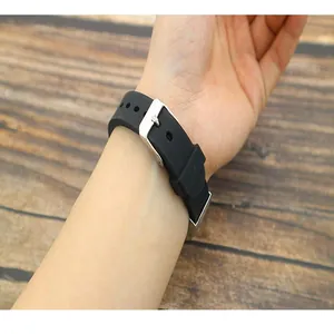 Detailed shot of a black silicone bracelet with a metal buckle worn on the wrist.