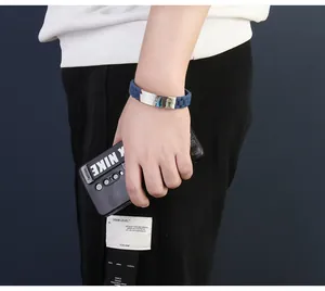 Close-up of men's blue silicone bracelet with polished stainless steel plate on wrist.