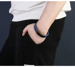 Close-up of blue silicone and black stainless steel men's bracelet on wrist.