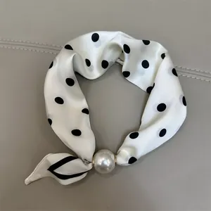 Elegant white silk scarf for women featuring black polka dots and a large pearl accent