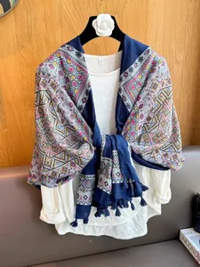 Detail view of the intricate ethnic patterns and tassels on the blue Bohemian shawl