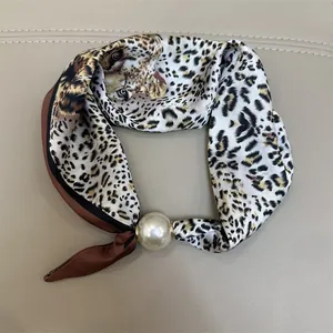 Elegante zijden sjaal met luipaardprint en een groot parel-accessoire voor dames