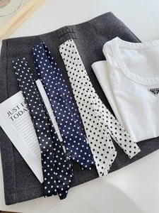 Detailweergave van drie lange polkadotsjaals in het zwart, marineblauw en wit.
