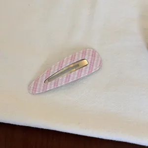 Vue macro détaillée d'une pince à cheveux à carreaux vichy rose et blanc pour filles