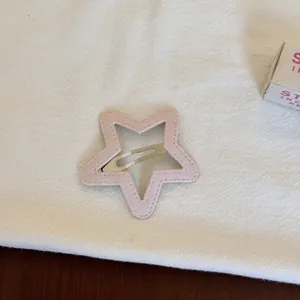 Vue détaillée de la pince à cheveux creuse rose en forme d'étoile avec tissu doux