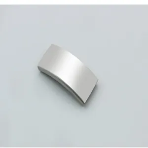 Close-up macro view of a curved stainless steel pet ID tag with a brushed matte finish