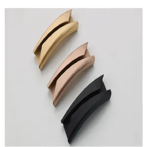 Macro view of three curved stainless steel bracelet tubes in gold, rose gold, and black finishes.