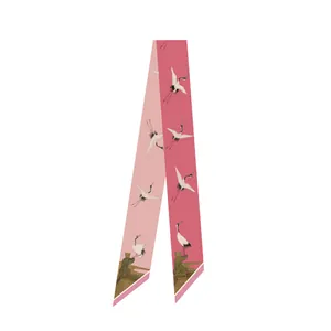 Detail van een smalle roze zijden sjaal met traditionele kraanvogel- en paviljoenprint