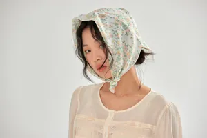 Detailed view of a vintage-style floral cotton headscarf with yellow and green print