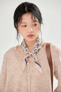 Close-up of a vintage French floral cotton square scarf worn by a model