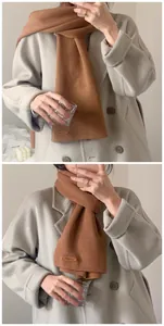 Detailansicht eines weichen, karamellfarbenen Strickschals zu einem Wollmantel
