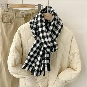 Primer plano de una bufanda a cuadros blancos y negros con chaqueta acolchada color crema
