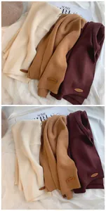 Weiche Strickschals in Beige, Camel und Burgunderrot auf einem Magazin-Hintergrund