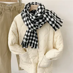 Bufanda de cuadros blancos y negros combinada con una chaqueta acolchada beige para el invierno.