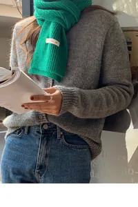 Sciarpa in maglia verde abbinata a un cardigan grigio per un look autunnale