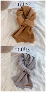 Detailansicht von weichen minimalistischen Strickschals in Karamelbraun und Hellgrau.