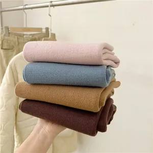 Hand hält weiche gestrickte Winterschals in Rosa Blau Camel und Braun für Damen