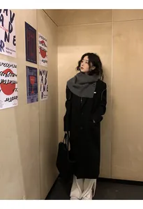 Stylish Asian model wearing a dark grey knitted button neck warmer with a black coat.
