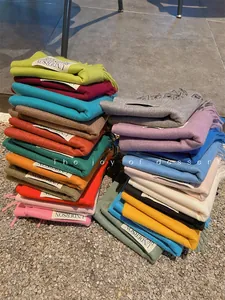 Stacked collection of colorful imitation cashmere scarves with stylish fringe details
