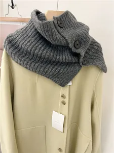 Detail of vintage grey knitted button neck warmer scarf on a beige winter coat