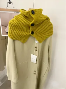 Detailed view of a retro mustard yellow knitted neck warmer with elegant black buttons