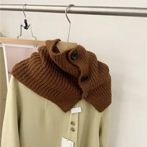 Close-up of brown knitted button neck warmer styled on a beige coat for winter fashion