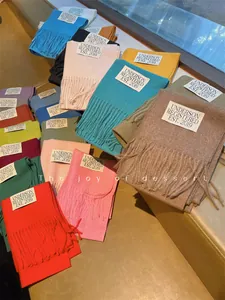 Close-up of vibrant solid color imitation cashmere scarves with decorative tassels