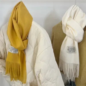 Detailed shot of yellow and cream imitation cashmere scarves with elegant fringes