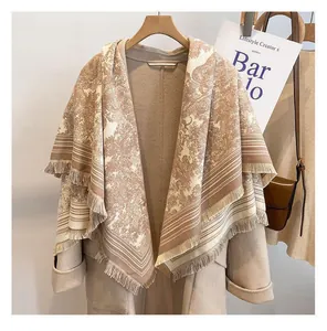 Close-up detail of a Toile de Jouy pattern shawl with fringe displayed on a hanger