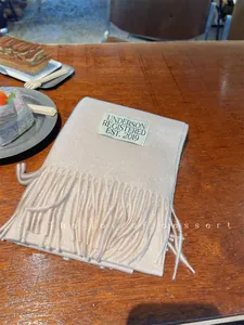 Soft beige imitation cashmere scarf with tassels and Underson label detail.