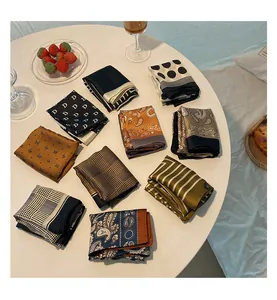 Collection of vintage-style silk square scarves with various patterns on white table