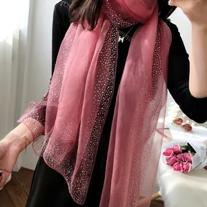 Élégante écharpe en soie de mûrier rose avec détails en strass portée par le modèle