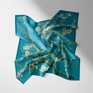 Detailed view of teal silk scarf with Van Gogh Almond Blossom print in a spiral fold