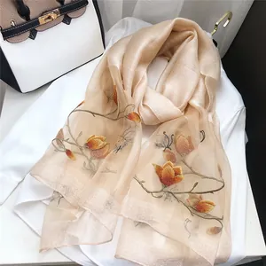 Close-up of elegant champagne scarf with detailed floral and butterfly embroidery
