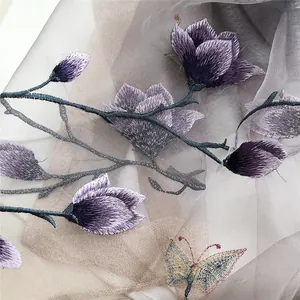Close-up of elegant purple floral and butterfly embroidery on sheer silk scarf fabric