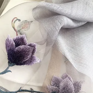 Detail showing elegant purple magnolia flower embroidery on sheer silk wool scarf