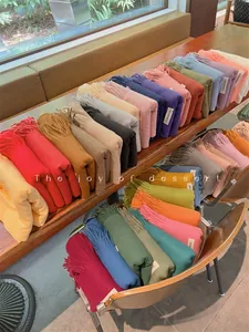 Large collection of soft solid-colored scarves with tassels in various vibrant colors