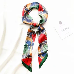 Vue détaillée d'un foulard en soie à fleurs colorées noué élégamment sur fond blanc
