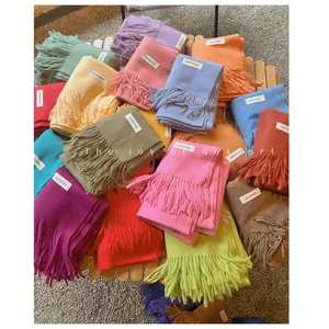 A collection of colorful soft scarves with fringes in various pastel and solid tones