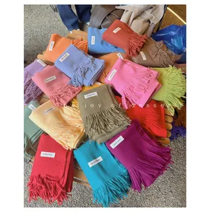 Detailed view of soft winter scarves in various vibrant colors with stylish tassel edges