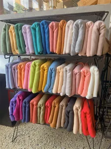 Detailed view showing a variety of colorful soft winter scarves with tassels on a rack