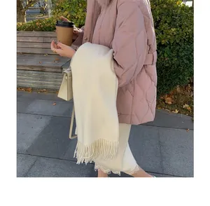 Close-up view of a soft cream white solid fringe scarf for elegant winter warmth