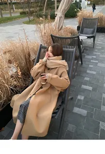 Detailed view of a woman wearing a soft tan winter scarf and a stylish camel long coat.