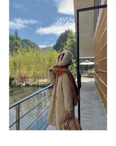 Woman wearing a warm thick brown scarf with tassels in a scenic winter setting