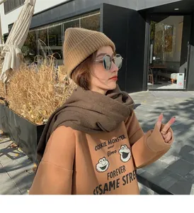 Detailed view of a soft brown winter scarf for women in a stylish outdoor street setting.