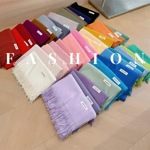 Flat lay of soft winter tassel scarves in multiple solid colors for a premium look