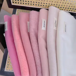 Close-up of soft knitted winter scarves in a gradient of pink and white shades