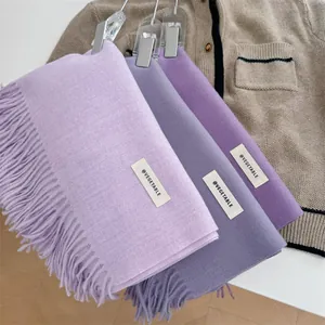 Macro view of soft smoke purple scarves in three different shades featuring decorative tassels.