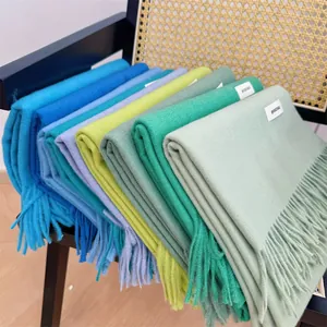 Detail view of various colorful winter scarves featuring soft tassels and woven texture