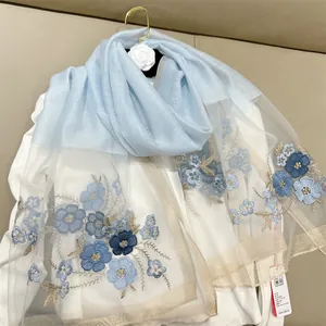 Detail view of light blue silk blend scarf with exquisite begonia floral embroidery